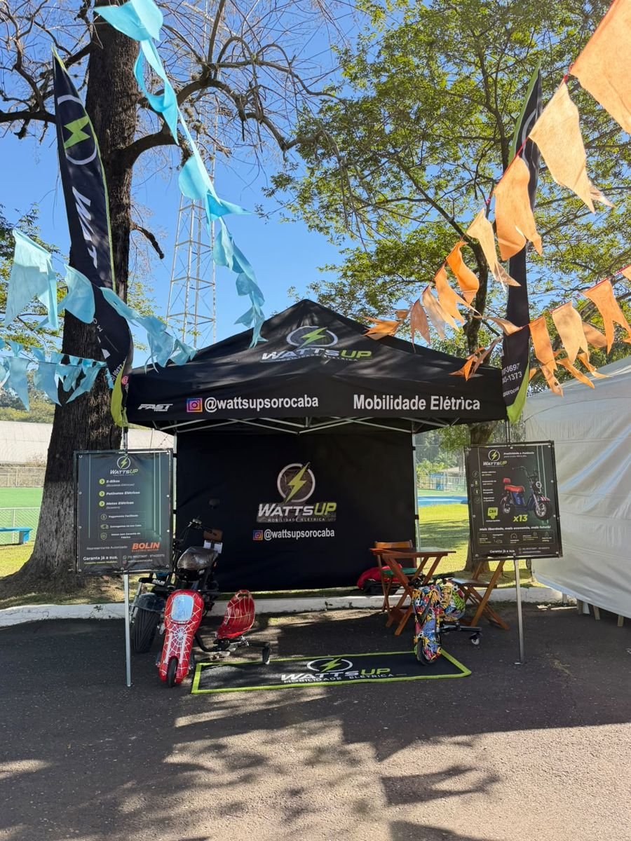 Estande da WattsUp com scooters e drift trikes em evento ao ar livre